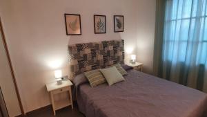 Un dormitorio con una cama con dos mesitas de noche y dos lámparas. en Hera House, en Parque Holandes