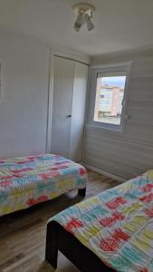 a bedroom with two beds and a window at Appartement T4, climatisation, 50m de la plage in Cap d'Agde
