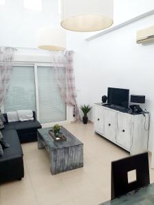 Una sala de estar con un sofá y un televisor. en Villa mit privatem Pool, zentrumsnah, en Roldán