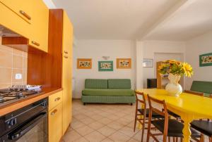 Una cocina y una sala de estar con una mesa y un sofá. en Agriturismo il Montoto - Nature & Relax, en Castiglione della Pescaia