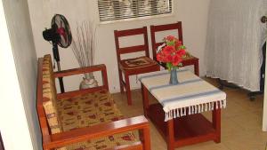 a room with chairs and a table with a vase of flowers at Lyn's Do Drop Inn Transient House in Baguio