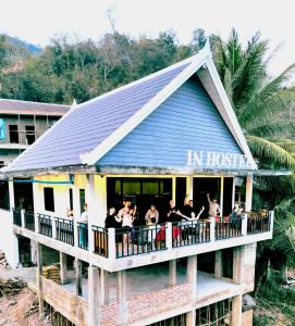 Un grupo de personas de pie en el balcón de un edificio. en INN RIVERSIDE HOSTEL Pb, en Pakbeng