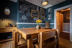 a dining room with a wooden table and blue walls at The King's Berth in Portree