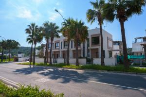 a building with palm trees on the side of a street at WealthyStays 2BR Retreat , 5Min Walk to Beach in Protaras