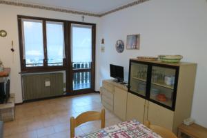- un salon avec une télévision et une table à manger dans l'établissement Appartamento Aurora, à Molina di Ledro