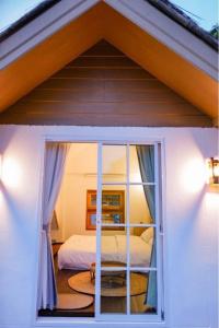um quarto com uma cama e uma janela em อาข่า พามิโอ้ em Ban Pha Mi