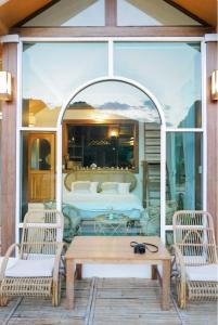 um pátio com 2 cadeiras, uma mesa e uma cama em อาข่า พามิโอ้ em Ban Pha Mi