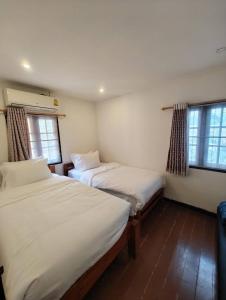 Postel nebo postele na pokoji v ubytování Merry house บ้านพักริมหาดบางแสน