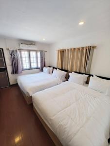 Postel nebo postele na pokoji v ubytování Merry house บ้านพักริมหาดบางแสน
