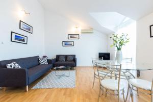 uma sala de estar com um sofá e uma mesa em Apartments Charming em Zadar