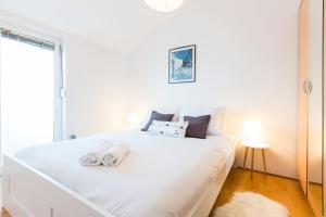 Un dormitorio con una cama blanca con toallas. en Apartments Charming, en Zadar