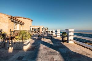 Una pasarela junto al océano con un edificio en Villa Albatros - piscine chauffée, en Saint-Mandrier-sur-Mer