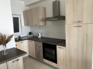 a kitchen with wooden cabinets and a stove top oven at Seafront studio apartment San Paul's Bay in St Paul's Bay