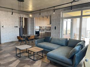 a living room with a blue couch and a kitchen at 7th Heaven in Nyíregyháza