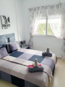 1 dormitorio con 2 camas con animales de peluche en Villa mit privatem Pool, zentrumsnah, en Roldán