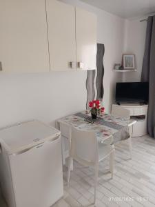 a kitchen with a table and chairs and a television at Studio cabine le grau du roi 6 min de la plage à pied in Le Grau-du-Roi +7 photos