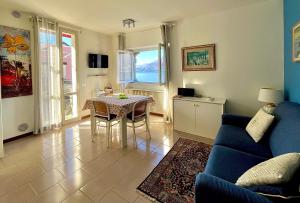 a living room with a table and a blue couch at Casa Mary Varenna in Varenna