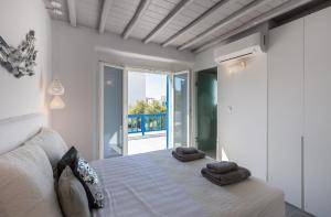 una camera da letto con un letto con due asciugamani sopra di Villa Iliana 1 & 2 w shared Pool, Ornos, Mykonos a Ornos Altre 70 foto