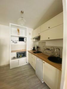 a kitchen with white cabinets and a sink at La Cassy - Sleep in Cassis in Cassis +10 photos