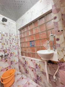 ハイデラバードにあるGuest House Single roomのタイル張りの壁、洗面台付きのバスルーム