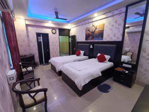 BegusaraiHotel Devi Darbar的酒店客房,配有两张床和两把椅子