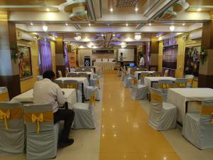 BegusaraiHotel Devi Darbar的用餐室配有白色的桌子和黄色的椅子
