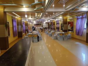 BegusaraiHotel Devi Darbar的建筑物内有桌椅的宴会厅