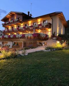 a large building with flowers on the balconies at night at Boutique Hotel Il Riccio - Adults Only in Roccaraso
