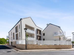 ein weißes Gebäude mit Balkonen an der Straßenseite in der Unterkunft Cosygreen77- Spacious apt with garden & parking, 7mns by car from Disneyland in Magny-le-Hongre