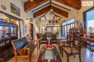 a living room with chairs and a table at StayVista at Beyond Infinity with Hill View, BBQ in Lonavala