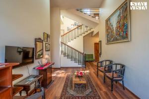 a hallway with a living room with a stair case at StayVista at Beyond Infinity with Hill View, BBQ in Lonavala