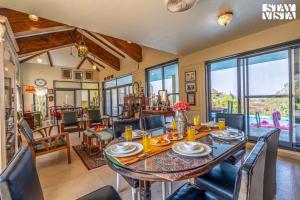 a dining room with a table and chairs at StayVista at Beyond Infinity with Hill View, BBQ in Lonavala