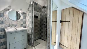 a bathroom with a shower and a sink and a mirror at Terre & Mer'veilles 2, appartement avec SPA pour 2 personnes in Favières