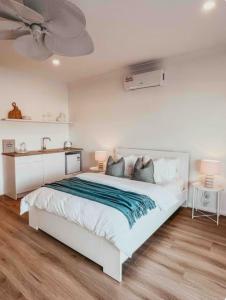 a white bedroom with a large bed and a ceiling fan at Harrington Guest Suite in Harrington