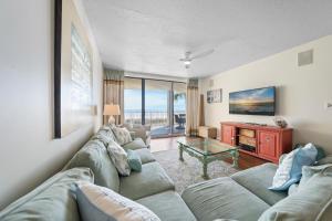 ein Wohnzimmer mit Sofa und Tisch in der Unterkunft White Caps 203 in Orange Beach