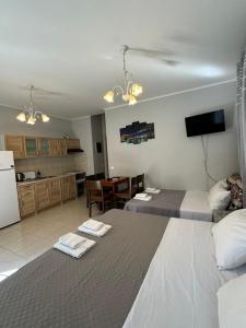 a room with two beds and a kitchen with a table at Suli Apartments in Limenas