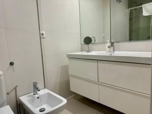 a white bathroom with a sink and a mirror at R4 Apartment next to Plaza de España and Metro in Seville