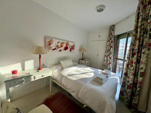 a bedroom with a bed and a desk and a window at R4 Apartment next to Plaza de España and Metro in Seville