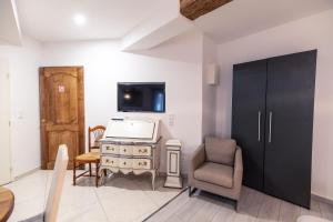 TV a/nebo společenská místnost v ubytování Chambre Familiale du Couvent