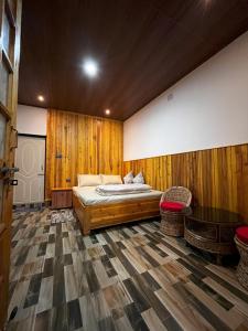 une chambre avec un lit et un mur en bois dans l'établissement Payun Homestays, à Darjeeling