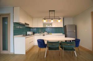 a kitchen with a table and some blue chairs at A Bridge House 1-B in Incheon