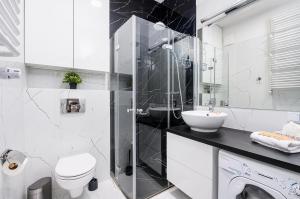łazienka z toaletą, umywalką i prysznicem w obiekcie Wola Cozy Apartment by P&O Apartments w Warszawie