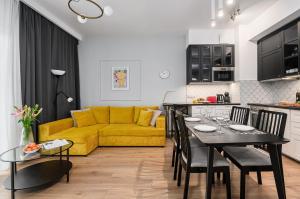 kuchnia i salon z żółtą kanapą w obiekcie Wola Cozy Apartment by P&O Apartments w Warszawie