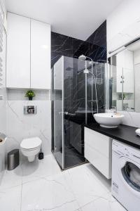 łazienka z toaletą, umywalką i pralką w obiekcie Wola Cozy Apartment by P&O Apartments w Warszawie +13 zdjęć