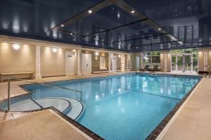 a large swimming pool in a large building at 2br-sleeps4-pool-freeparking-trenythonestate in Par