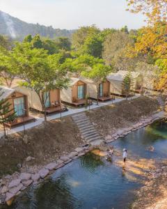 two people walking in a river near some tents at Season camp cha-om in Kaeng Khoi +26 photos