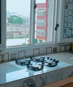 a stove top oven in a room with windows at residence Eden Garden 1 in Abidjan