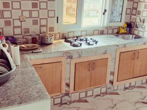 a kitchen with a sink and a stove top oven at residence Eden Garden 1 in Abidjan