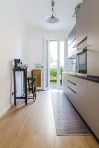 una cucina con mobili bianchi e pavimento in legno di DrEaM of VeNiCe - Free parking - Ground floor a Venezia