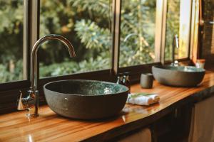 a bathroom counter with two sinks and a window at Honeywood Forest Lodge in Port Shepstone +52 photos